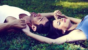 close up of romantic couple lying on the grass 1139 332 696x398